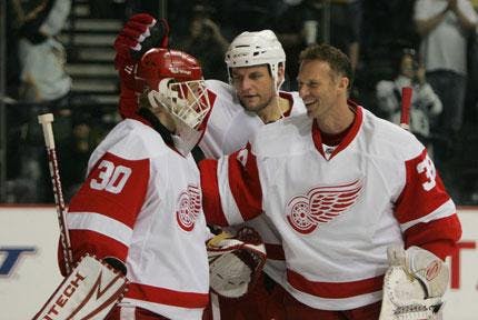Detroit goalie Chris Osgood (left) is congratulated by teammates Darren McCarty (center) and Dominik Hasek on his shutout against Nashville on Sunday. The Red Wings won 3-0 and took the series, 4-2.