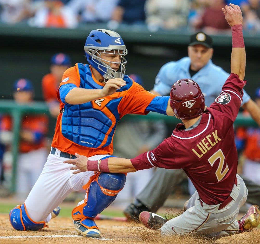Florida catcher JJ Schwarz (22) tags out Florida State's Jackson Lueck (2) at home to end the fourth inning of an NCAA college baseball game in Jacksonville, Fla., Tuesday, March 29, 2016. Florida won 3-2. (Gary Lloyd McCullough/The Florida Times-Union via AP)