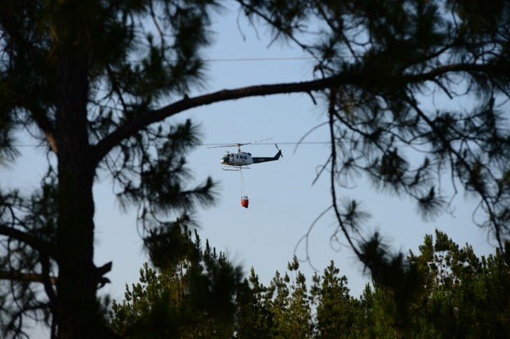 A fire-fighting helicopter is seen from the corner of County Road 225 and County Road 1475 Friday afternoon.&nbsp;