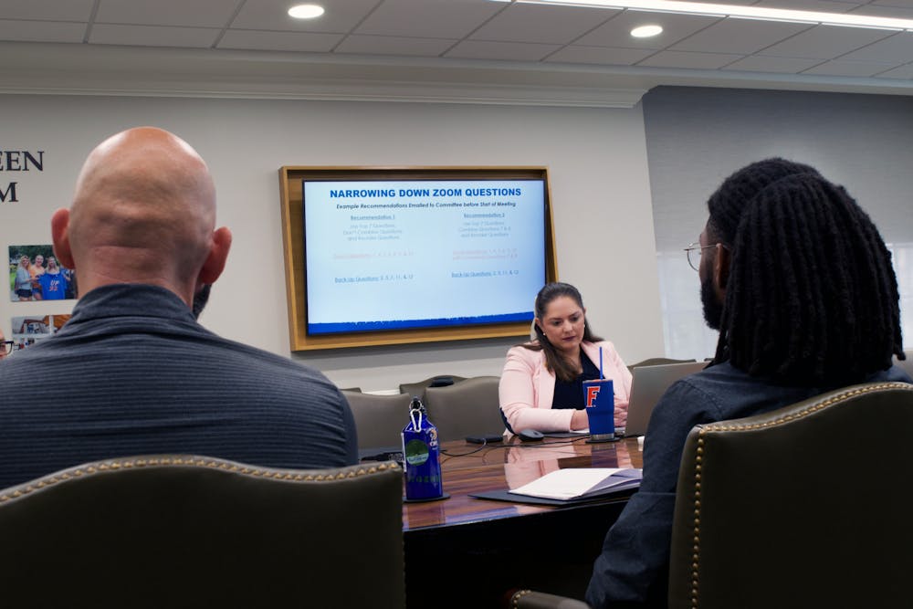 <p>Three members of the search committee for the Director of the Honors Program review interview questions in the Dr. C. Author Sandeen conference room Friday, Feb. 17, 2023.</p>