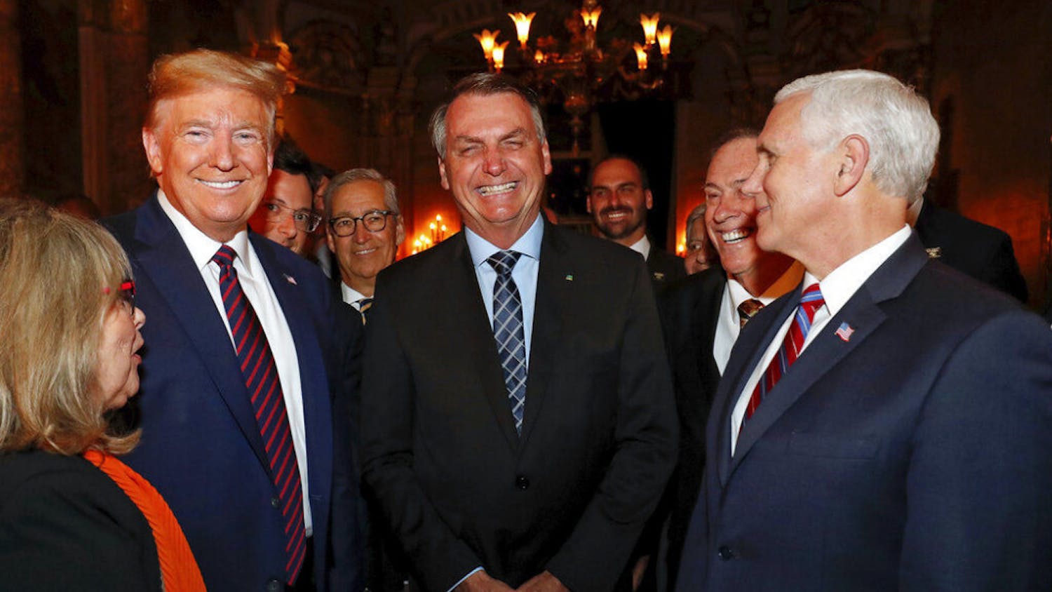 In this March 7, 2020 photo provided by Brazil's presidential press office, Brazil's President Jair Bolsonaro, center, stands with President Donald Trump, second from left, Vice President Mike Pence, right, and Brazil's Communications Director Fabio Wajngarten, behind Trump partially covered, during a dinner in Florida. Wajngarten tested positive for the new coronavirus, just days after the trip, according to Bolsonaro's communications office on Thursday, March 12, 2020. (Alan Santos/Brazil's Presidential Press Office via AP)