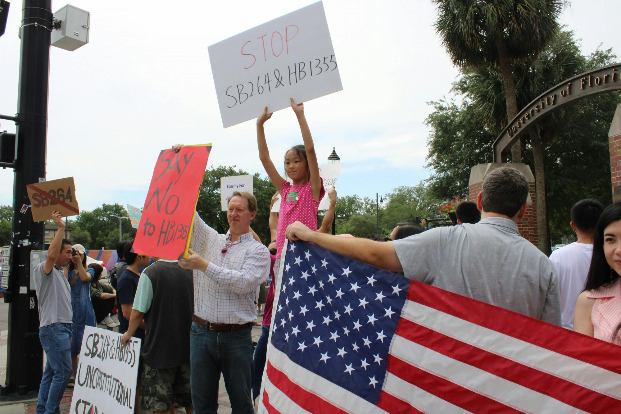 Emily Chen, 8, holds up a sign protesting the proposed Interest of Foreign Countries Senate and House Bills at Southwest 13th Street and University Avenue on Saturday, April 29, 2023. Her mother, Liman Wei, said she wants her daughter to speak out against discrimation.