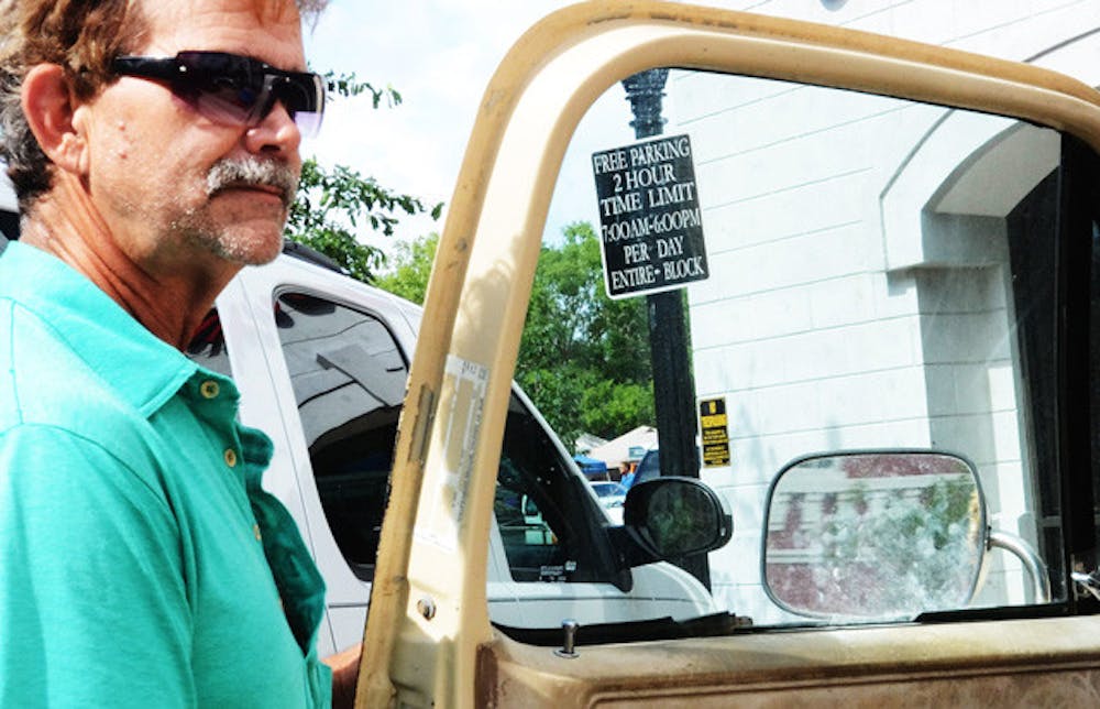 <p>Edward Dowling enters his truck in front of a free parking sign near The Hampton Inn &amp; Suites in downtown Gainesville Wednesday.</p>