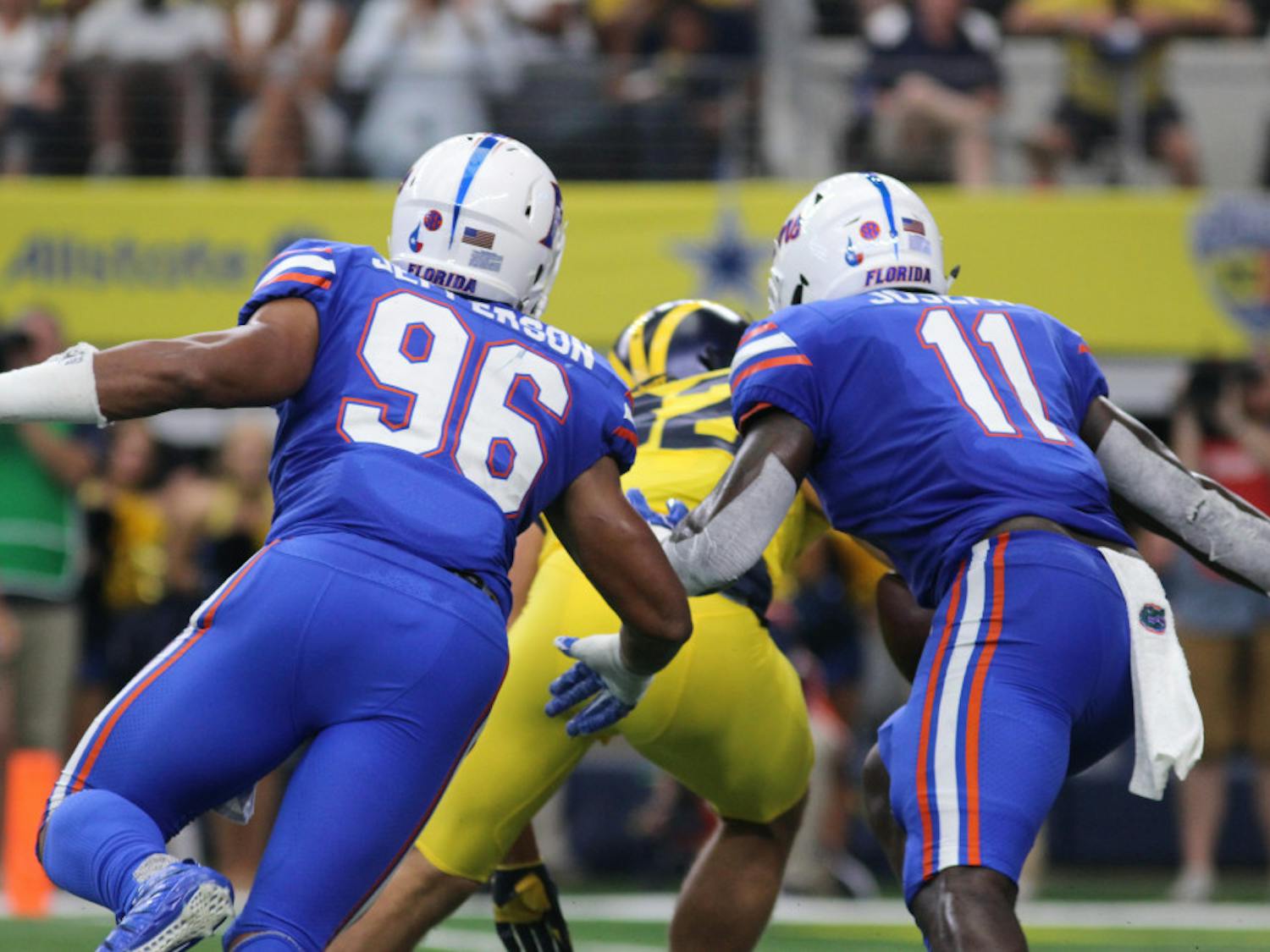 Cece Jefferson (96) and Vosean Joseph make a tackle during Florida's 33-17 loss against Michigan on Sept. 2, 2017, at AT&T Stadium in Arlington, Texas.