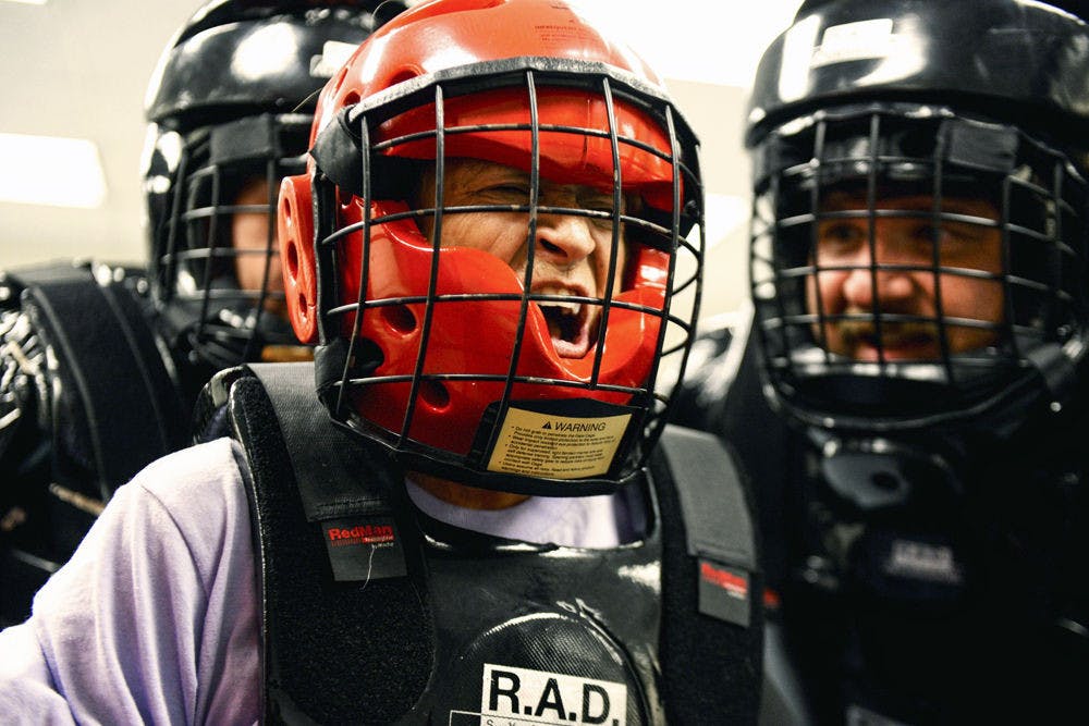 <p>Susan Gonzalez (center), participates in a R.A.D. exercise in which Capt. Ray Tremblay (right), of the City of Chiefland Police Department, acts as the aggressor.</p>