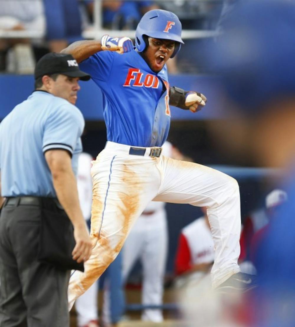 <p>Josh Tobias celebrates after scoring a run in the top of the ninth against North Carolina State Sunday. Tobias drove in the eventual winning run for Florida in the 10th frame.</p>