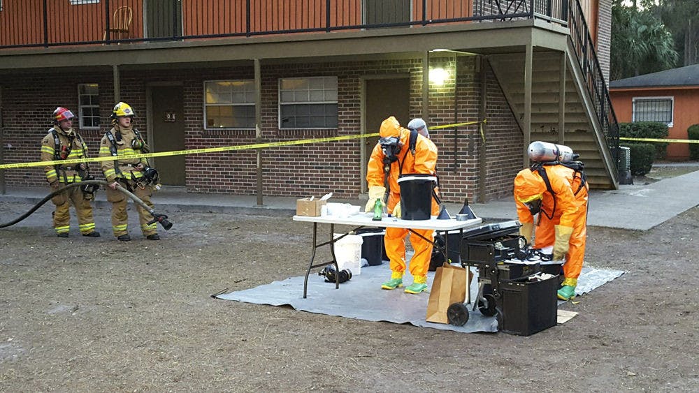 Hazmat workers examine meth lab equipment found inside Village Green Apartments on Tuesday. Police arrested two Gainesville residents they said produced the drug in the same apartment as a 5-year-old boy.