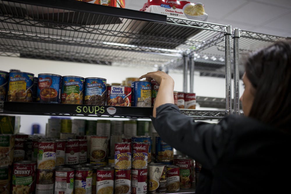 <p>A volunteer stocking shelves with canned food at the Field and Fork Pantry on UF's campus in 2016. </p>