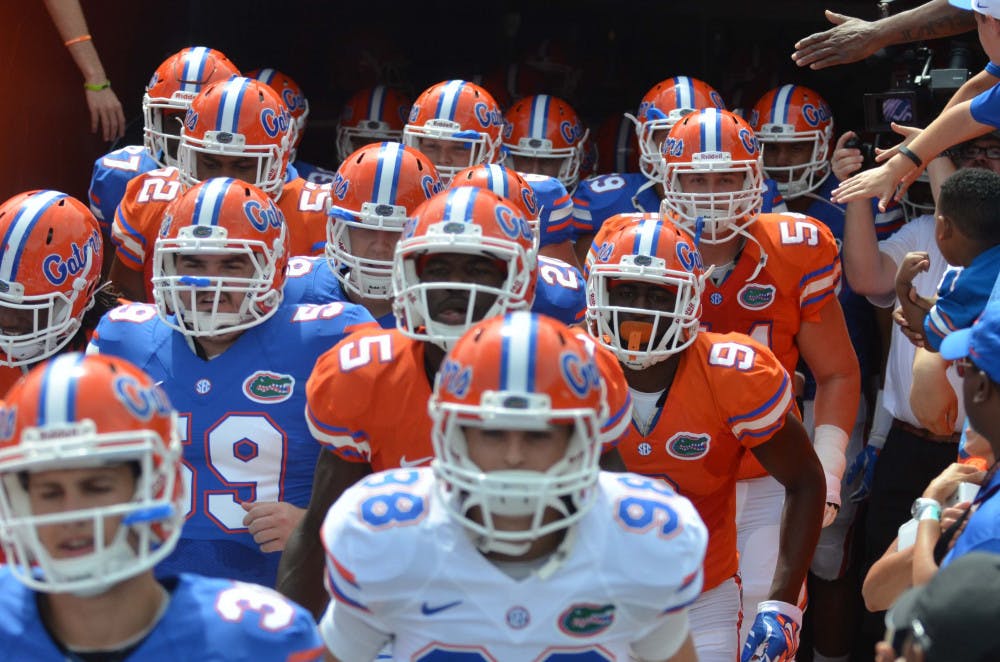 <p>Florida football playes run out of the tunnel during the 2015 Orange and Blue Debut Spring game April 11, 2015, at Ben Hill Griffin Stadium.</p>