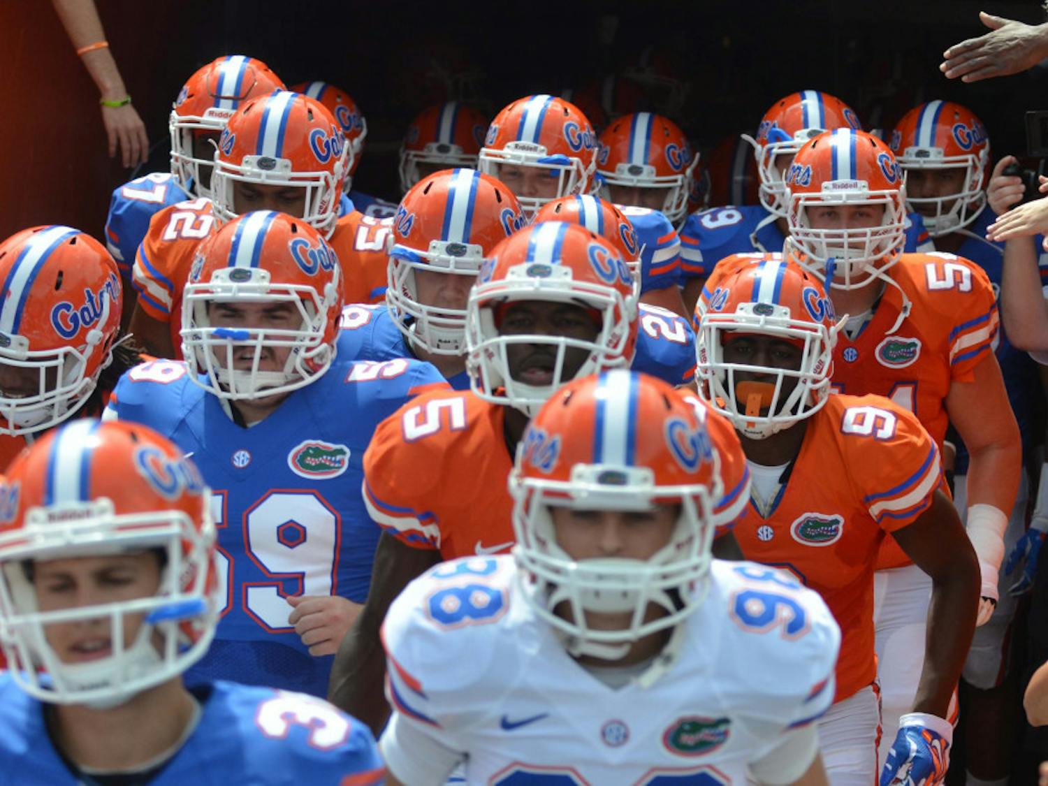 Florida football playes run out of the tunnel during the 2015 Orange and Blue Debut Spring game April 11, 2015, at Ben Hill Griffin Stadium.