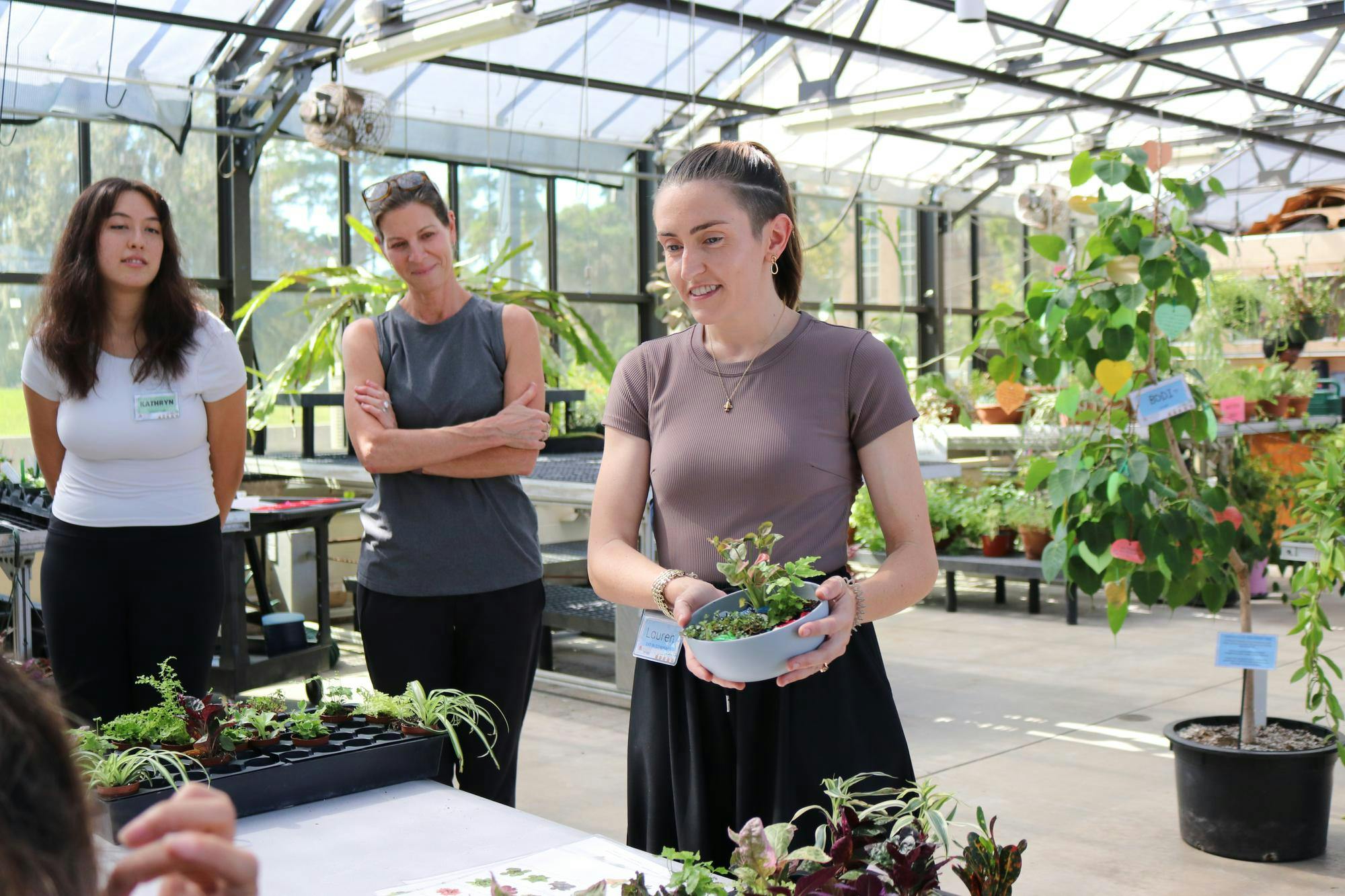 Program manager Lauren St. Clair displays her finished pixie plant bowl to participants in the Therapeutic Horticulture Program in the greenhouse at Wilmot Botanical Gardens on Tuesday, Oct. 14, 2025.