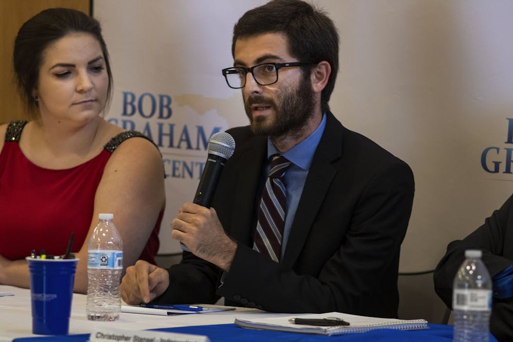 <p>Inspire President Zachary Amrose (right) speaks at the debate Monday night. To his left sits <span>Ashley Grabowski, former Inspire Senator and current Inspire Party campaign manager.</span></p>
