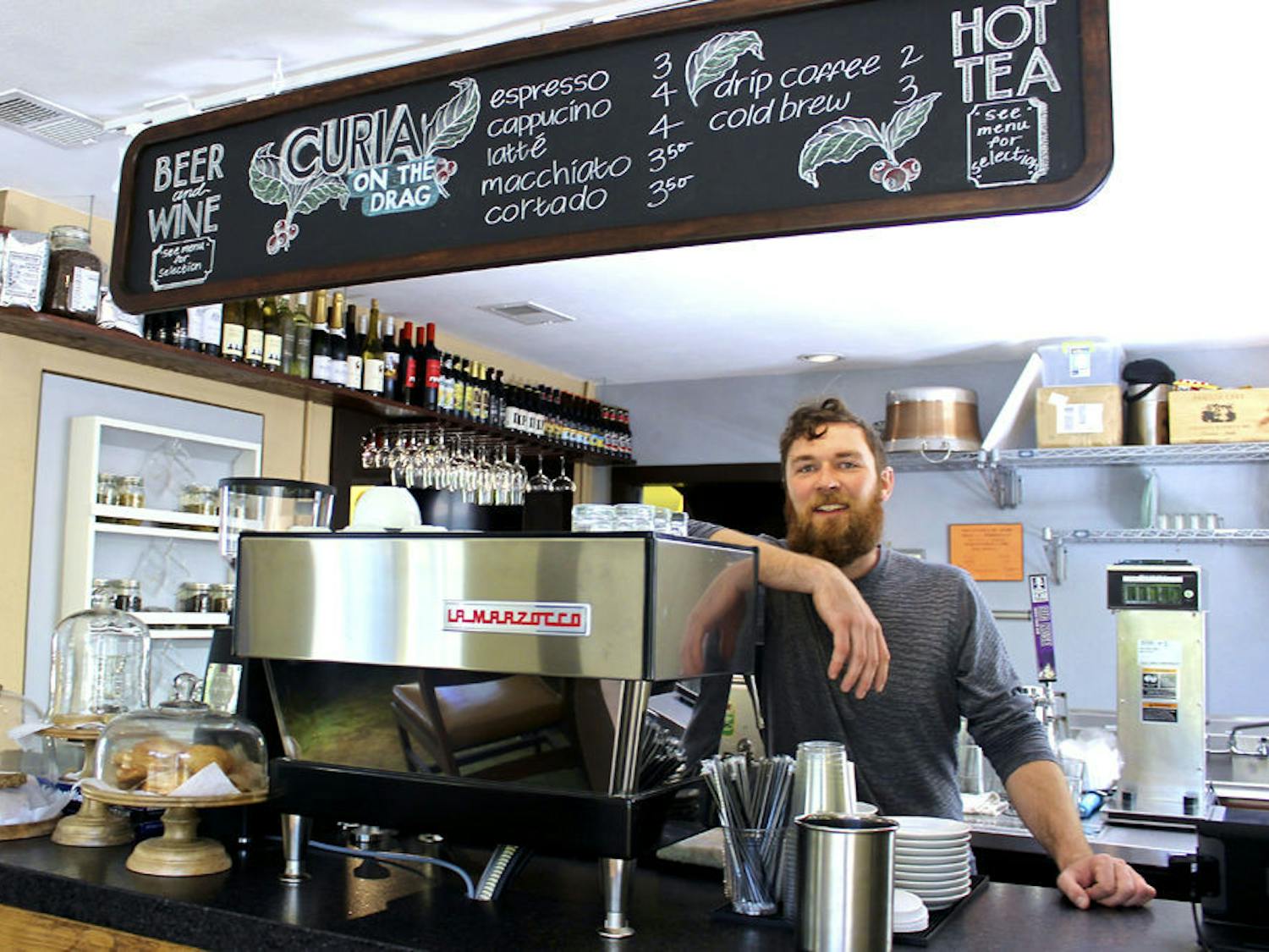 Zack Kennedy, the 31-year-old operating director for Curia on the Drag, poses for a photo inside the coffee shop located on 2029 NW 6th St. “We want to be a destination spot for the community,” Kennedy said. “We want this to be a spot where you can come and hang.”