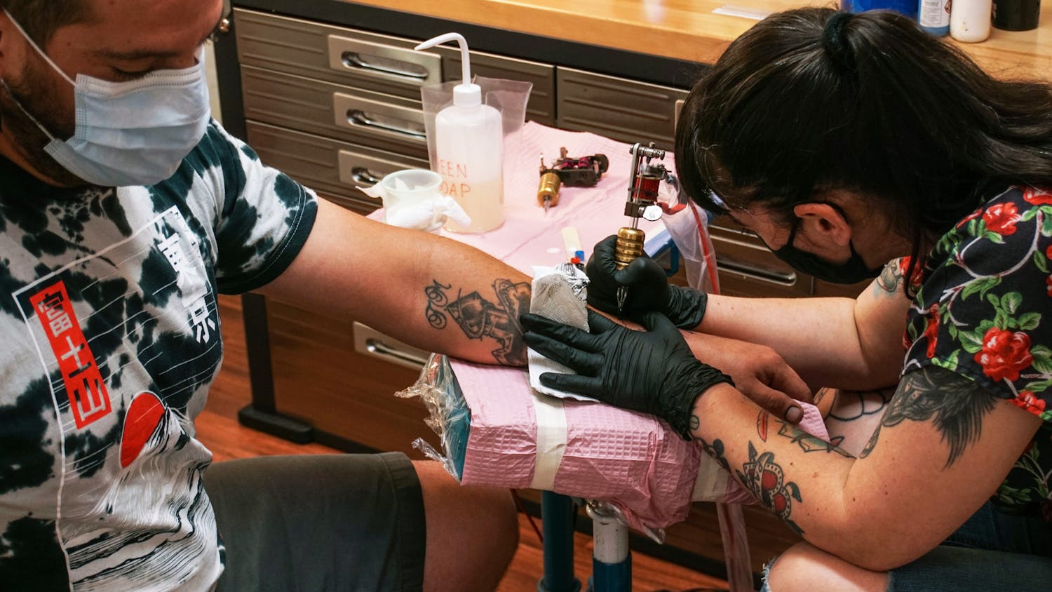 Kristyn Lopez, 37, (right) gives a tattoo designed to emulate a tarot card to Franciso Martinez, 31, a Gainesville resident (left) on Sunday, June 13, 2021.