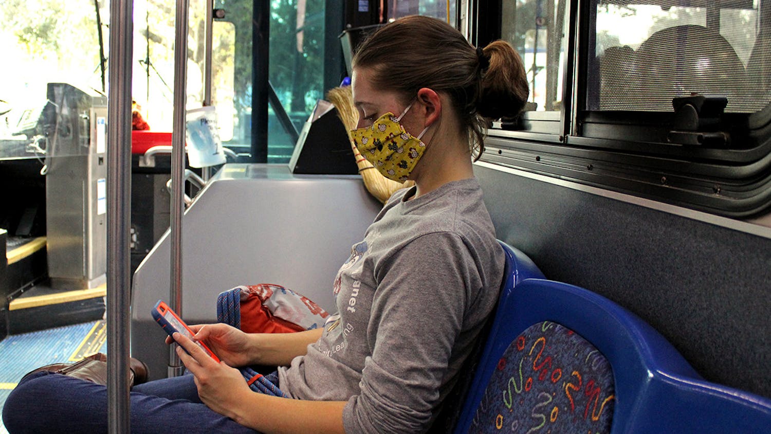 Lillie Rooney, a 20-year-old UF Entomology senior, sits on  RTS Bus 35 at the J. Wayne Reitz Union stop on campus on Sunday, Jan. 10, 2021. RTS is adding more buses to existing routes 12, 13, 20 and 38, continuing mask mandates and keeping capacities low for buses this Spring.