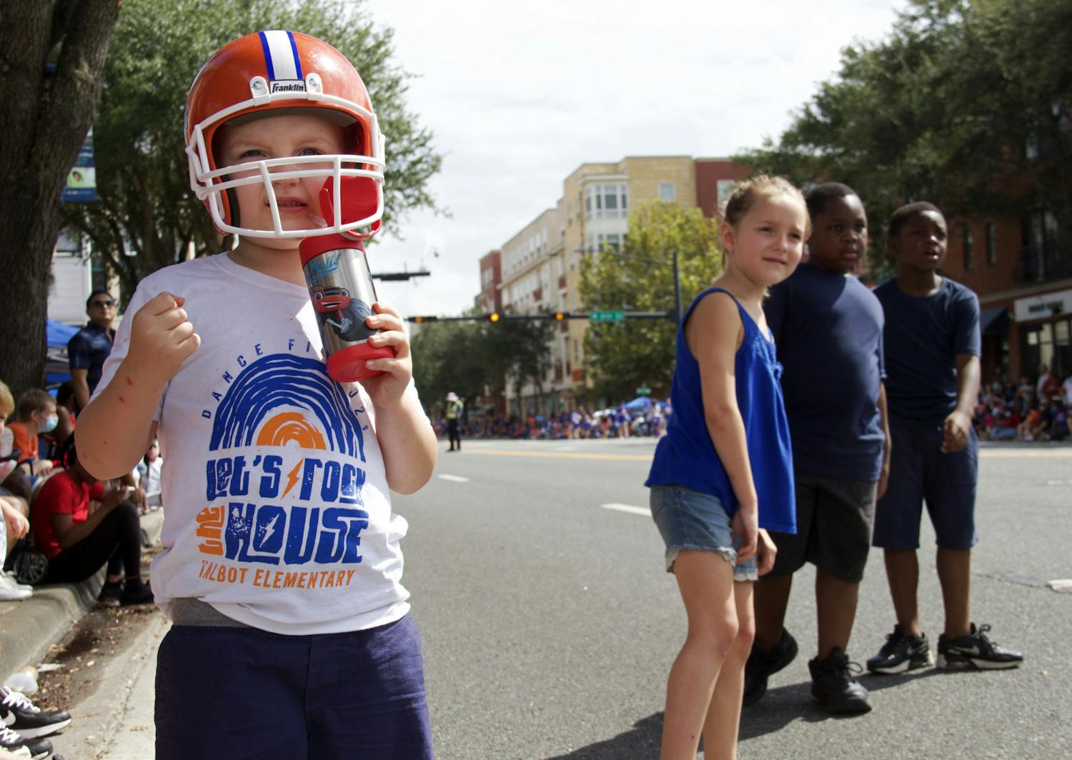 Gavin Hughes (left), Haddie Hughes (middle), and twins Emanuel and Elijah Harmon (right) watch the UF Homecoming Parade approach on University Avenue on Friday, Oct. 8, 2021.