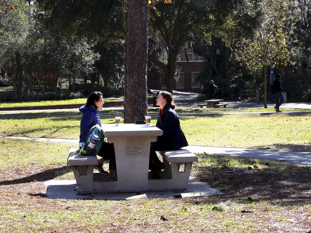 Steph Jamis from Maryland and Elise Morrison from California, both UF soil and water science graduate students, catch up over coffee outside the Hub on Tuesday morning. “We are having a philosophical talk,” Steph said. “The chilly weather certainly influences our thinking when we set out to start the day, but the coffee has been a good help so far counteracting the weather’s effects.”