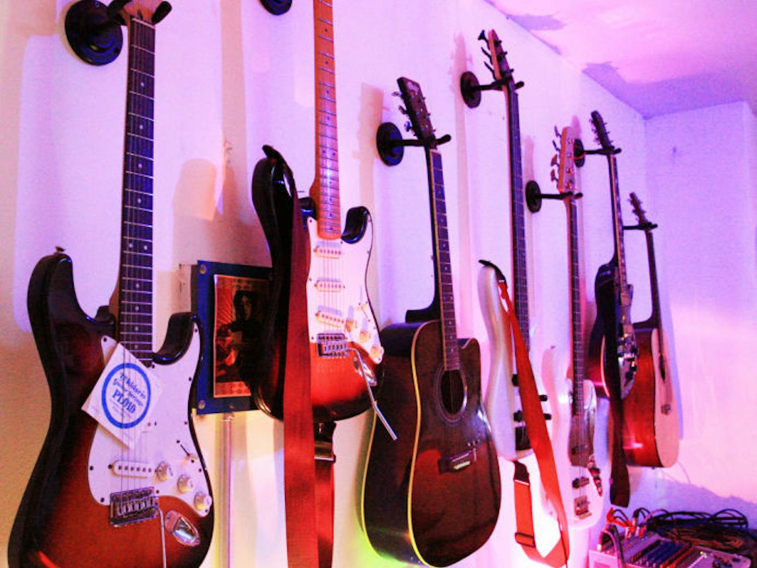 Guitars hang on the wall of The JAM, 817 W. University Ave., waiting to be played by patrons. Anyone can use the bar’s instruments, which include guitars, drums and a piano, to rock on the stage.