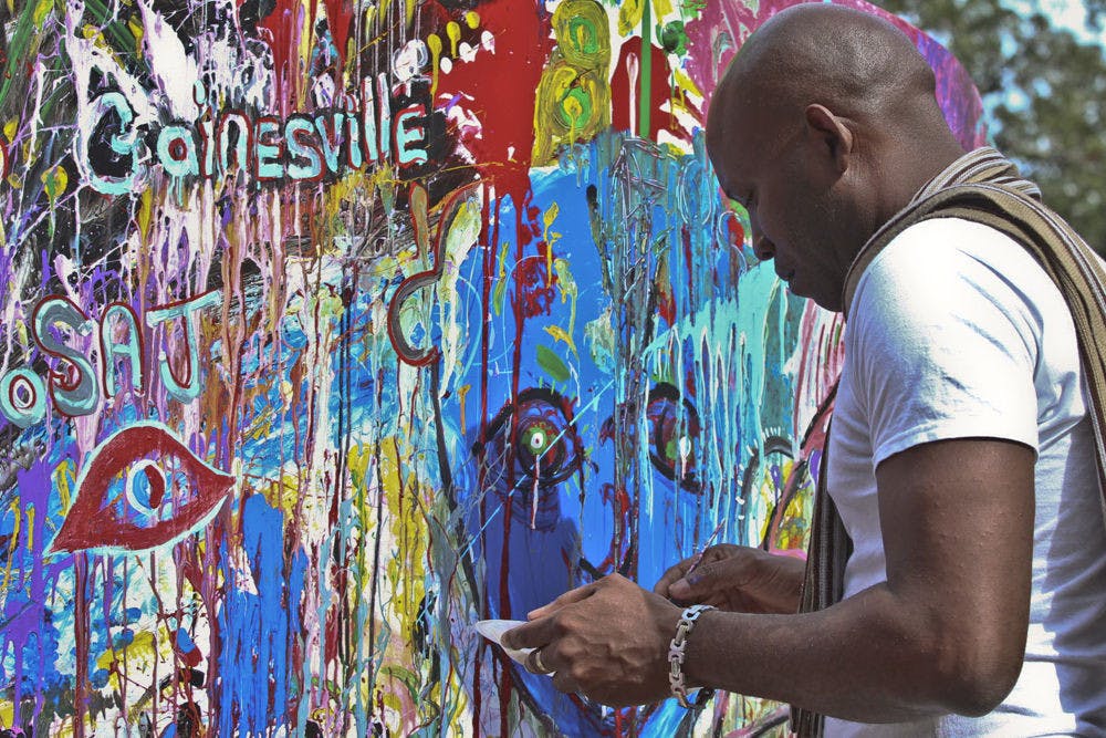 <p>Artist Jean Garibaldi paints a canvas at the annual Gainesville Downtown Festival &amp; Art Show on Nov. 15, 2015. The $100,000 festival went covered downtown Gainesville from Friday through Sunday.</p>