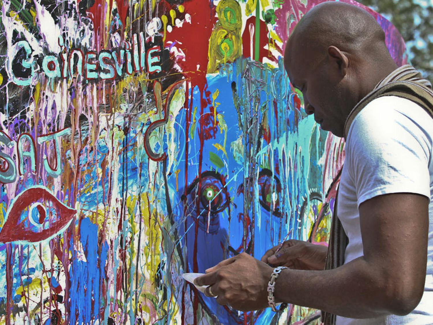 Artist Jean Garibaldi paints a canvas at the annual Gainesville Downtown Festival & Art Show on Nov. 15, 2015. The $100,000 festival went covered downtown Gainesville from Friday through Sunday.
