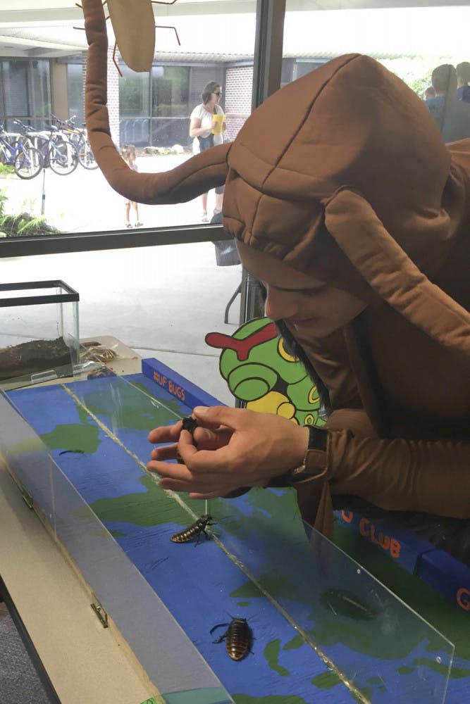 Michael Gonzalez, a graduate student in the UF department of entomology and nematology, holds a Madagascar hissing cockroach at the entomology BugFest on Saturday morning in Steinmetz Hall.