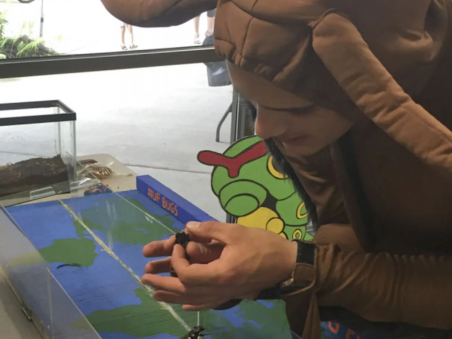Michael Gonzalez, a graduate student in the UF department of entomology and nematology, holds a Madagascar hissing cockroach at the entomology BugFest on Saturday morning in Steinmetz Hall.