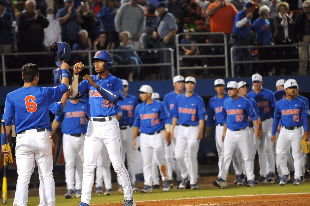 <p>Outfielder Buddy Reed celebrates with teammate Jonathan India (6) after hitting a three-run home run during Florida's 10-4 loss to Mississippi State on April 9, 2016, at McKethan Stadium.</p>