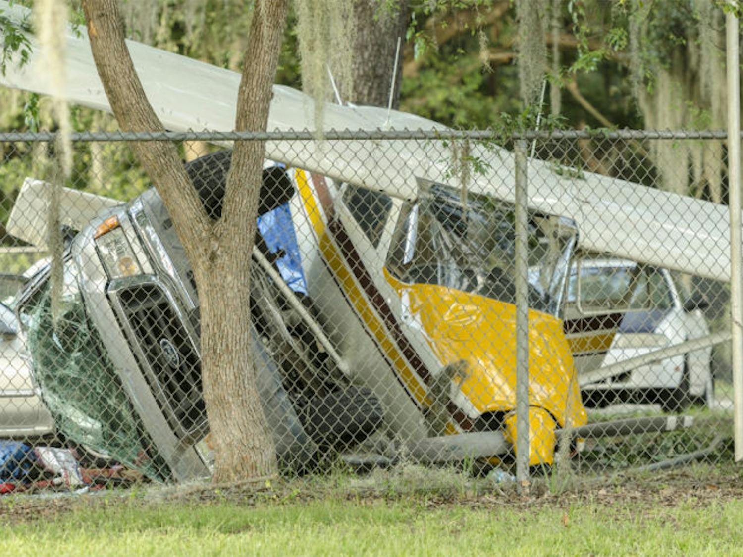 The front end of a pickup truck and a Cessna&nbsp;172F Skyhawk are seen on Flavet Field after the plane crashed, injuring two.