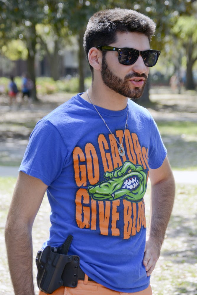 Gabriel Mondry, a 19-year-old UF health science sophomore, stands on Plaza of the Americas as part of an empty holster demonstration Wednesday afternoon. Mondray, who was wearing a an outside-the-waistband type holster, said the point of the demonstration was to show others that holsters are unobtrusive.
