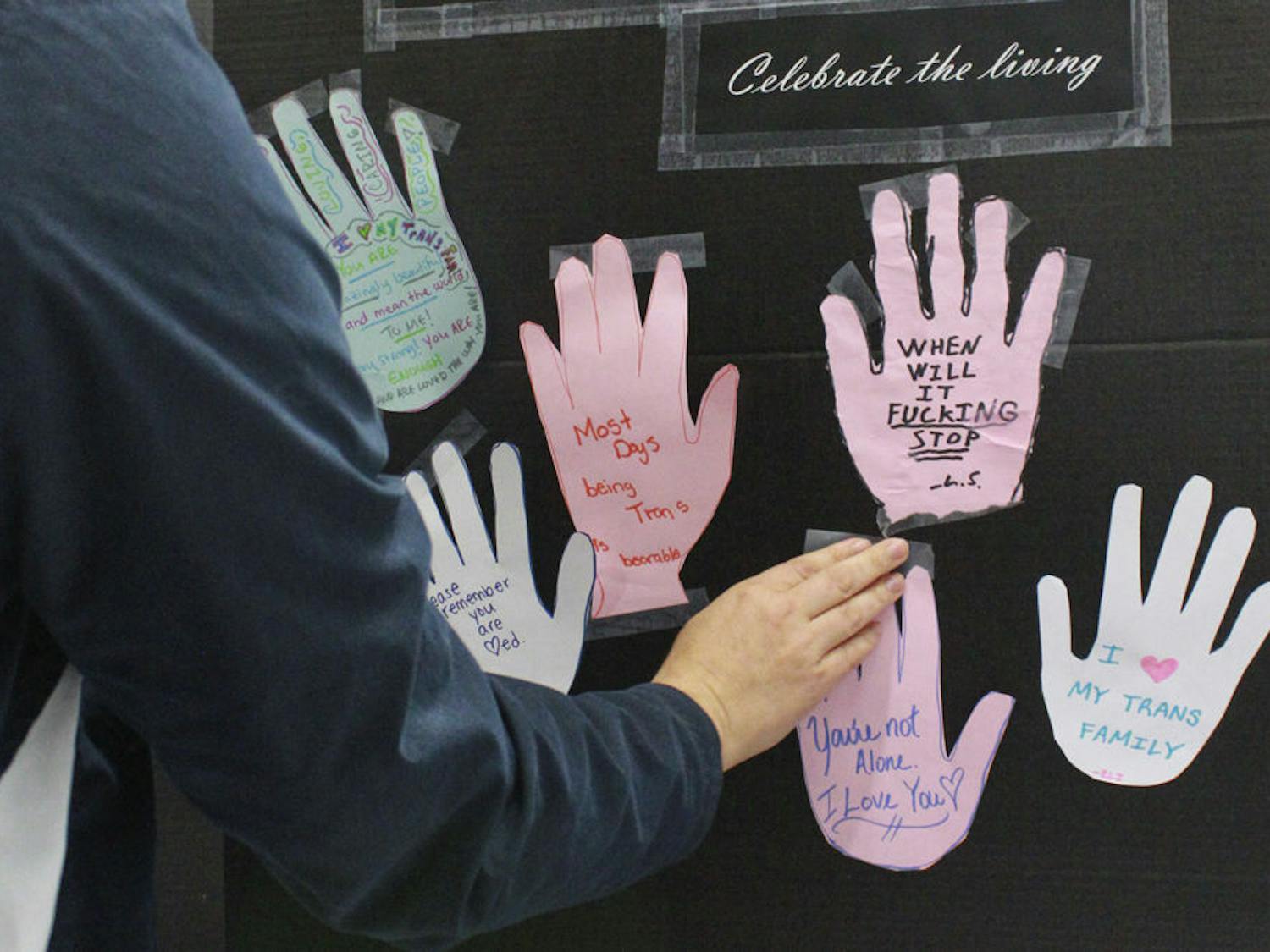 Students posted their white, pink or blue paper handprints with words of rememberance on a board that will be displayed on the Plaza of the Americas Nov. 20, 2015. The colors represent the transgender pride flag.