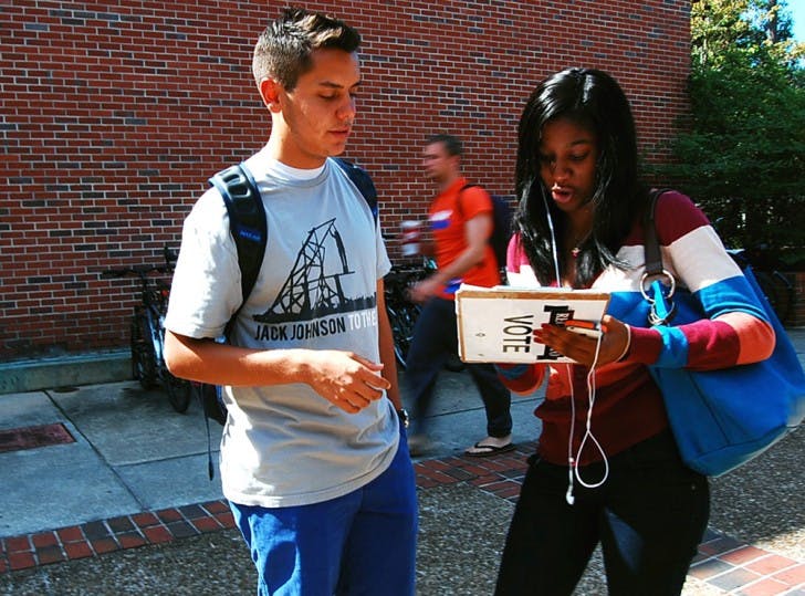 Sport management sophomore Joe DaSilva, 19, helps Rolanda Charles, 18, get registered to vote on Monday afternoon.