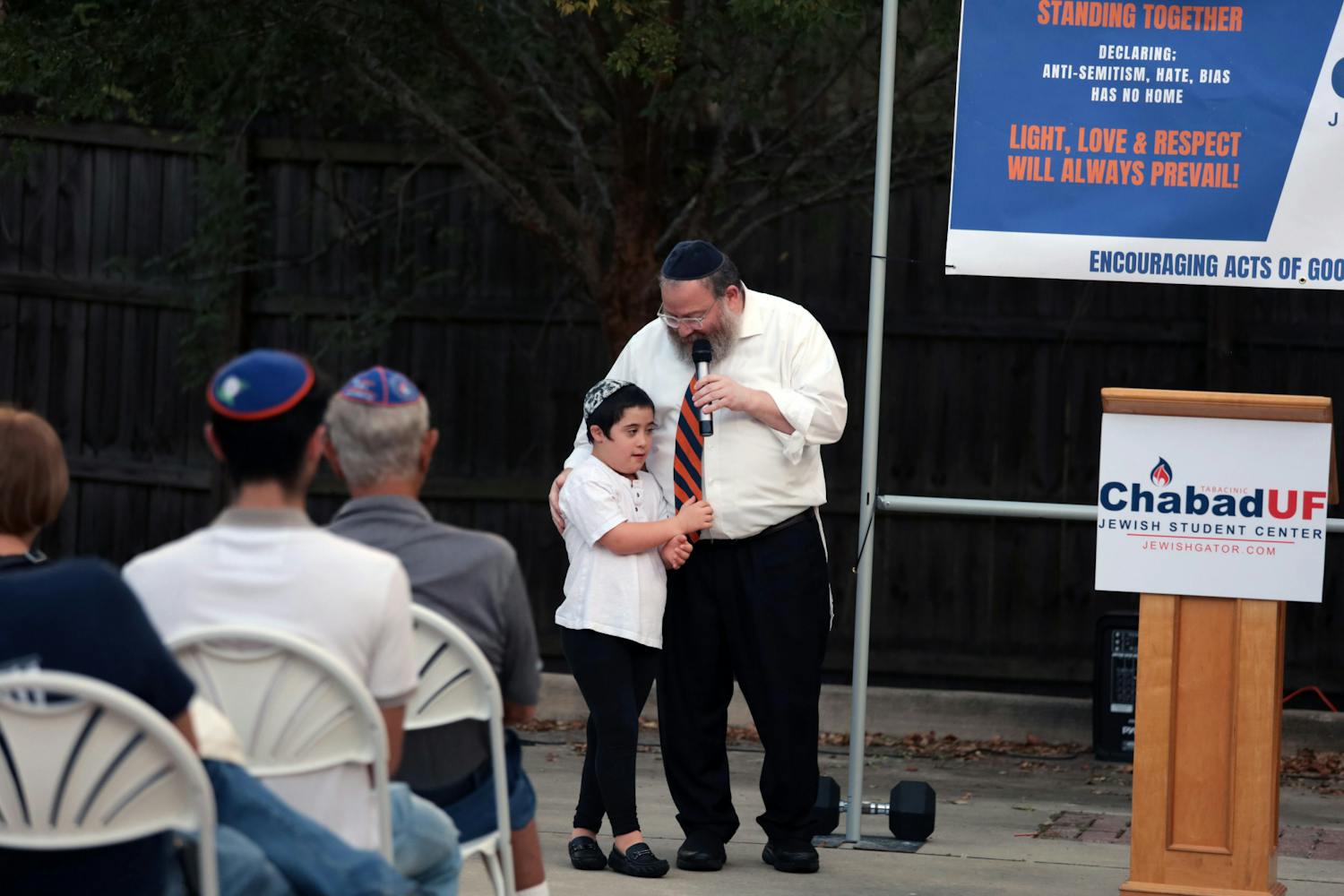 Rabbi Berl Goldman and his son Boruch stand in front of attendees at the Solidarity and Unity Rally held at Chabad UF Jewish Student and Community Center Friday Nov. 4, 2022.