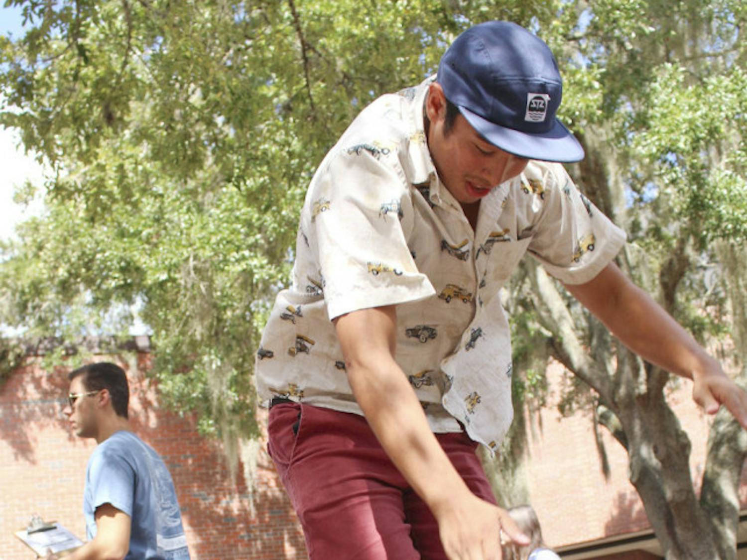 Jonathan Tiongco, a 20-year-old UF biology junior, balances on an Indo board at Turlington Hall on Oct. 8, 2015. Tiongco, the vice president of UF’s wakeboarding team, promoted “WakeFest: the Sequel,” which will take place at Lake Warburg’s south shore on Saturday.