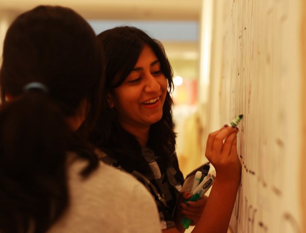 <p>Business administration sophomore Shruti Shah, 18, adds to the Hispanic heritage poster at the Samuel P. Harn Museum of Art’s Museum Nights: Hispanic Heritage on Thursday night.</p>