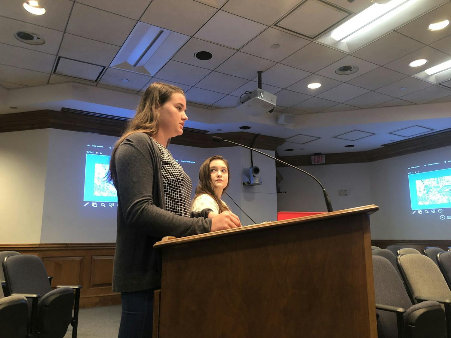 Alissa Humphrey (front left) presents her project with her partner Keelyn Fife (back right). Their presentation included the idea for a new plaza and medical center on the east side of Gainesville.