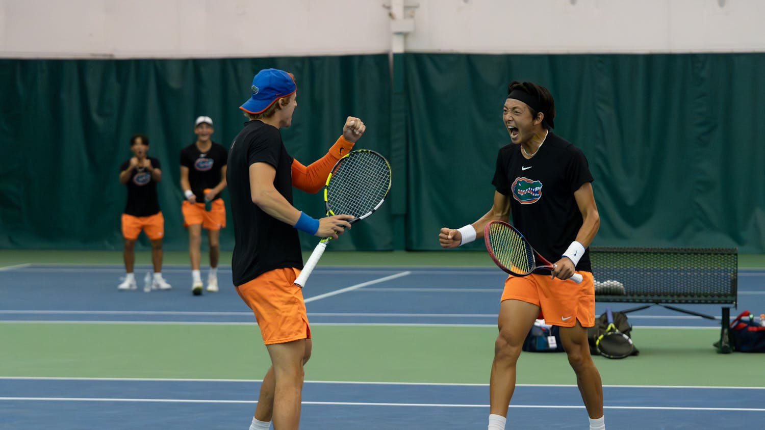 Gators men's tennis pairing of junior Nate Bonetto and freshman Aidan Kim celebrate winning a point in their match against Ole Miss on Friday, March 22, 2024. 