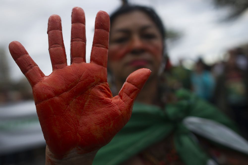 An indigenous woman shows her hands painted in red, representing blood, during a protest in defense of the Amazon while wildfires burn in that region, in Rio de Janeiro, Brazil, Sunday, Aug, 25, 2019. Experts from the country's satellite monitoring agency say most of the fires are set by farmers or ranchers clearing existing farmland, but the same monitoring agency has reported a sharp increase in deforestation this year as well. (AP Photo/Bruna Prado)