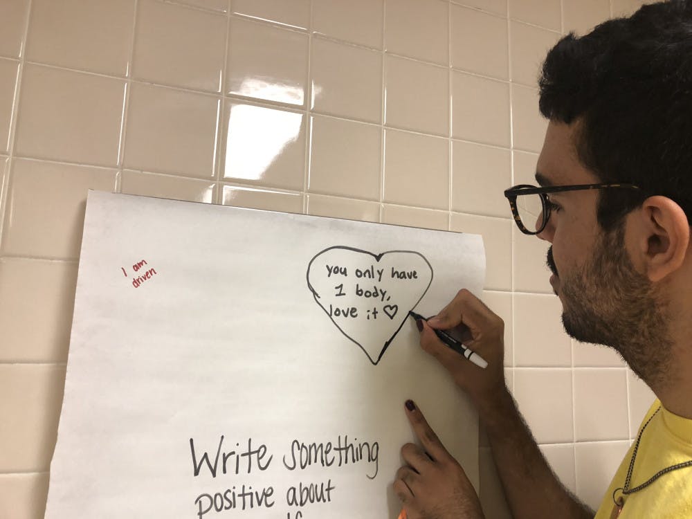<p><span>Anthony Flores, a 20-year-old UF visual art studies sophomore, traces a heart around a message they wrote. </span></p><div class="yj6qo"> </div><p><span style="color: #222222; font-family: arial, sans-serif; font-size: 12.8px;"> </span></p>