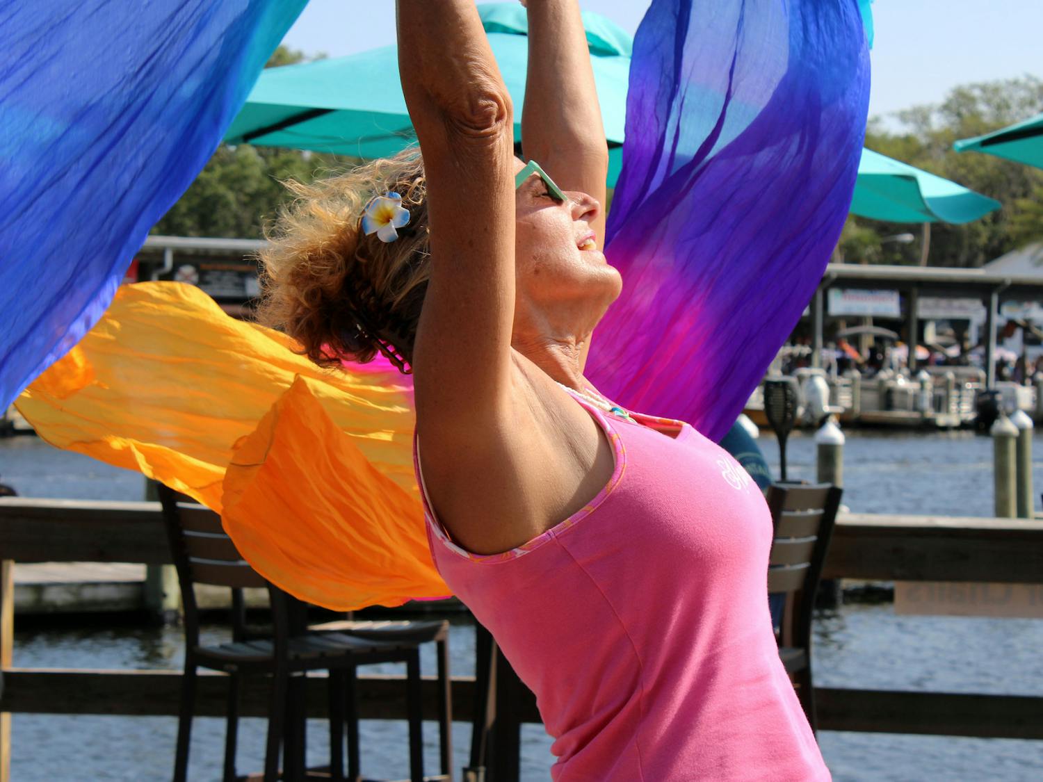 Elaine Hargrove, a 63-year-old Chiefland, Florida, resident, dances with colorful scarves at Crump’s Landing restaurant in Homosassa, Fla., on Sunday, April 16, 2023.