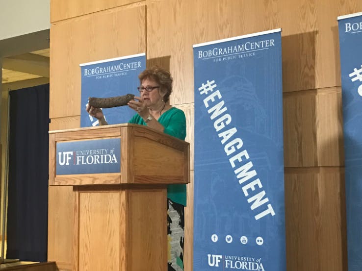 Martha Peterson Shogi holding a package shaped like a log, also known as a dead drop, &nbsp;that the CIA used to deliver materials to a Soviet diplomat who sent secret information to the CIA.