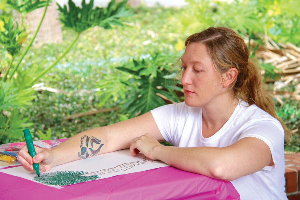 Lizzy Snow, a graduate intern with the Center for Arts and Medicine, draws a picture to support a research study hosted by 352 Creates. The 29-year-old will be running events for 352 Creates on Friday at The Midnight, including coloring book and collage making as well as instructing a hip-hop workshop.