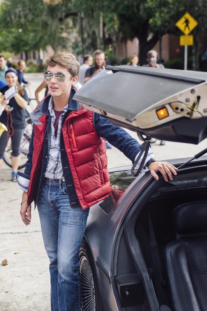 Trace Hance, a 21-year-old telecommunication senior, poses for a group of about 600 students with his DeLorean car on the Plaza of the Americas on Oct. 21, 2015, for Back to the Future day celebrations. “As I stepped out of the car, the band parted and then I saw a semi-circle of phones staring at me,” Hance said.