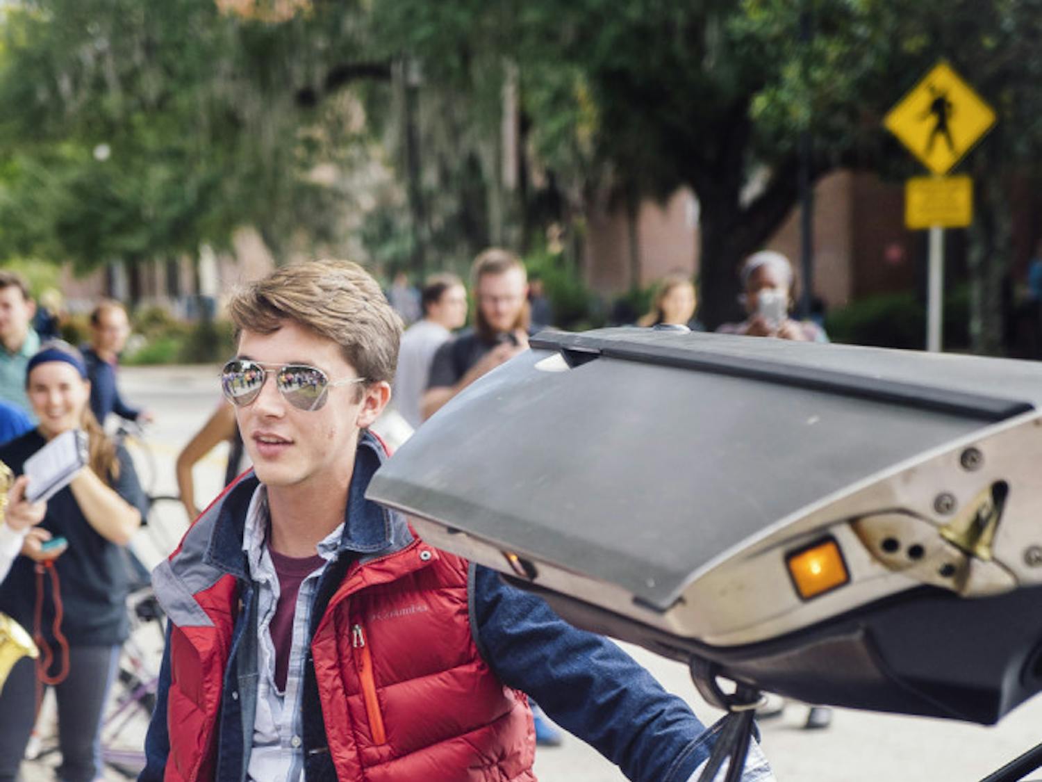 Trace Hance, a 21-year-old telecommunication senior, poses for a group of about 600 students with his DeLorean car on the Plaza of the Americas on Oct. 21, 2015, for Back to the Future day celebrations. “As I stepped out of the car, the band parted and then I saw a semi-circle of phones staring at me,” Hance said.