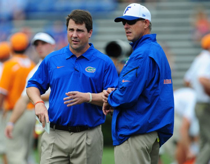 Second-year offensive coordinator Brent Pease speaks with coach Will Muschamp during warm-ups prior to Florida’s 31-17 victory against Tennessee on Saturday in Ben Hill Griffin Stadium.
