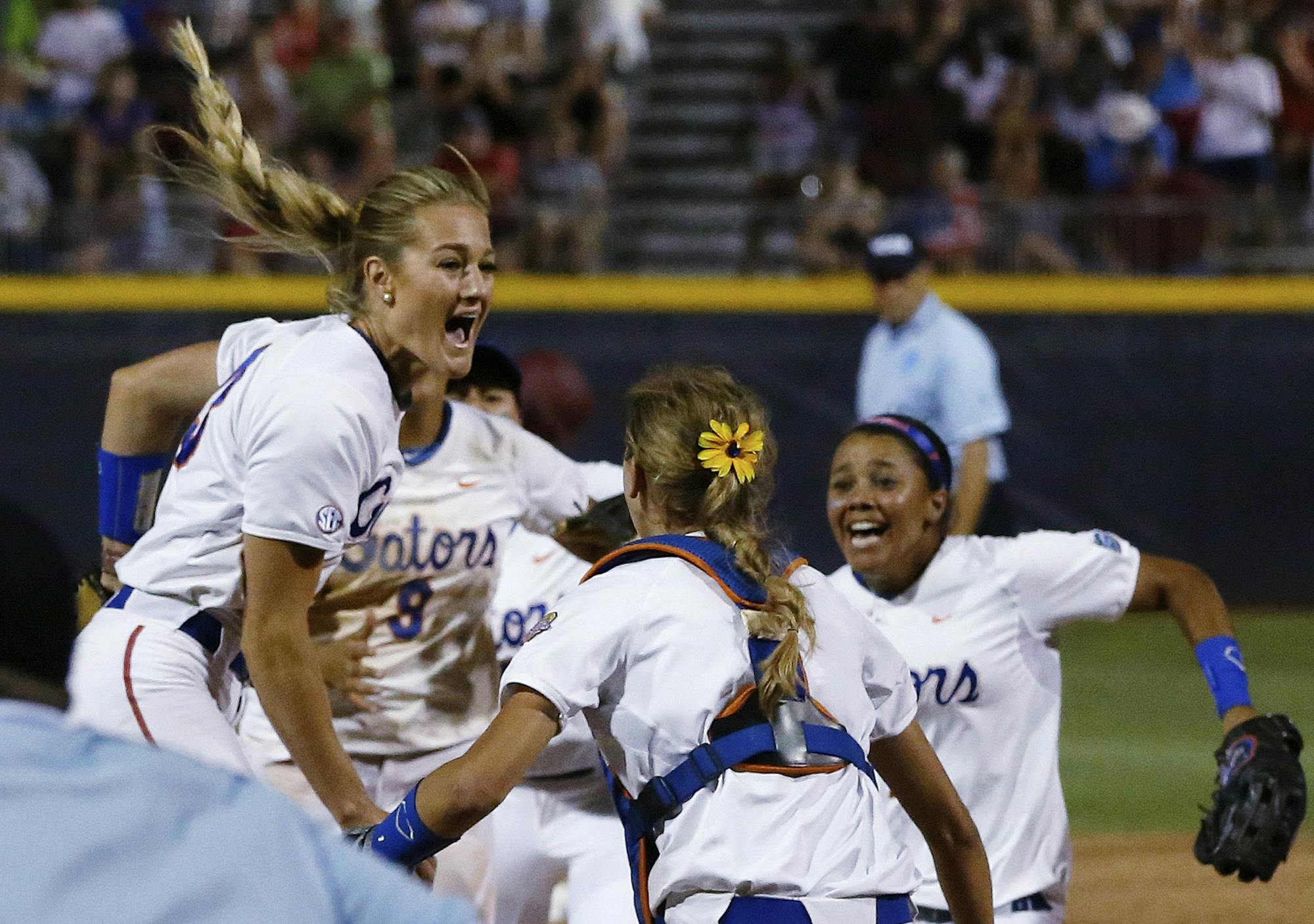 Florida pitcher Hannah Rogers, left, celebrates with teammates Aubree Munro (1) and Kelsey Stewart, right, after Tuesday night’s win.