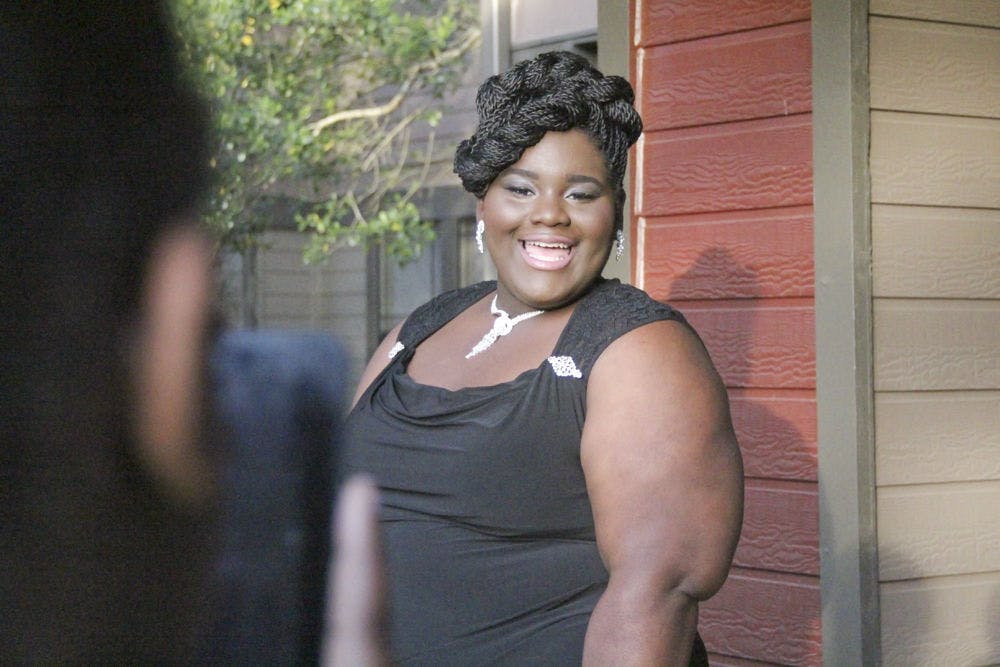 Lashayvia Searcy, a 17-year-old Eastside High School junior, poses while her mother, Alisa Mosley, takes her photo. Searcy won a prom giveaway put on by two UF graduates worth approximately $475.