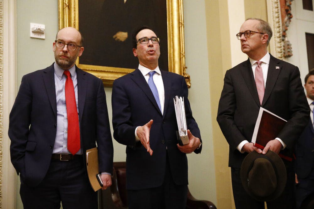 Treasury Secretary Steve Mnuchin, center, speaks with members of the media as he departs a meeting with Senate Republicans on an economic lifeline for Americans affected by the coronavirus outbreak. on Capitol Hill in Washington, Monday, March 16, 2020. (AP Photo/Patrick Semansky)