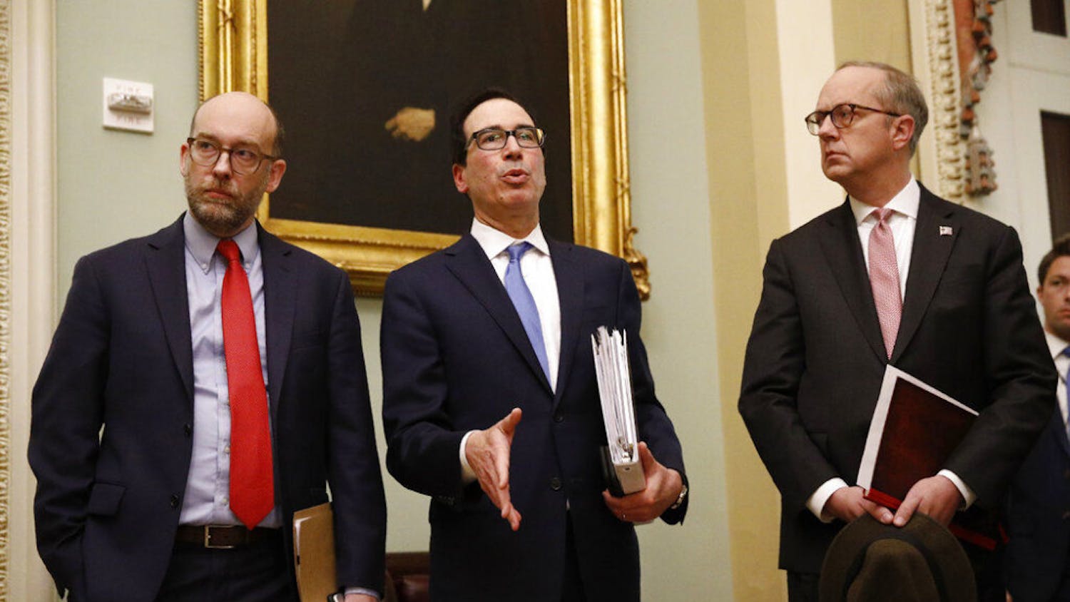 Treasury Secretary Steve Mnuchin, center, speaks with members of the media as he departs a meeting with Senate Republicans on an economic lifeline for Americans affected by the coronavirus outbreak. on Capitol Hill in Washington, Monday, March 16, 2020. (AP Photo/Patrick Semansky)
