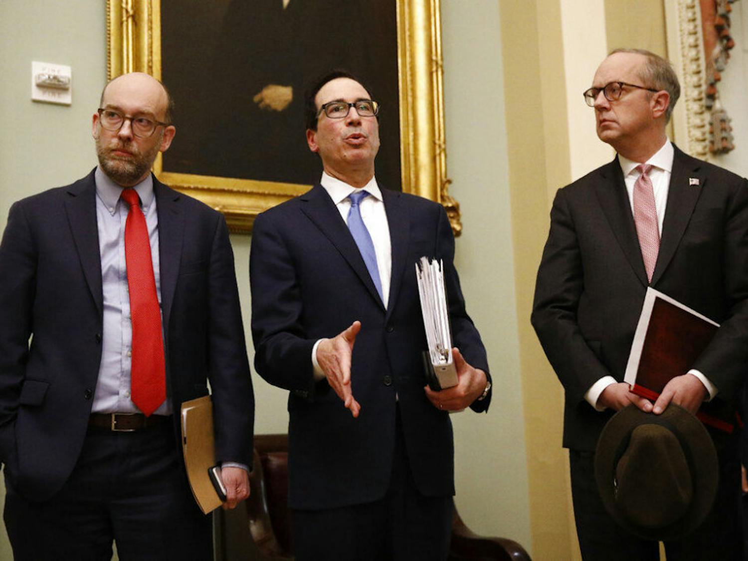 Treasury Secretary Steve Mnuchin, center, speaks with members of the media as he departs a meeting with Senate Republicans on an economic lifeline for Americans affected by the coronavirus outbreak. on Capitol Hill in Washington, Monday, March 16, 2020. (AP Photo/Patrick Semansky)