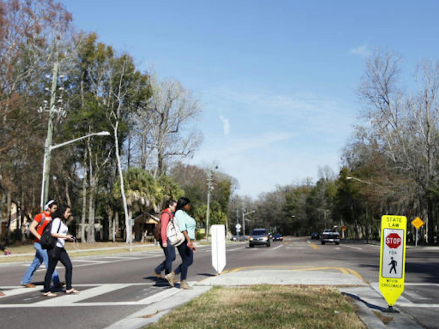 Pedestrians cross Southwest 62nd Street on Wednesday afternoon. Gainesville Police issued more than 120 traffic citations near the crosswalk during the past two days, a majority of which went to drivers.